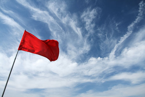 red flag against blue sky with white clouds | Colorado red flag law